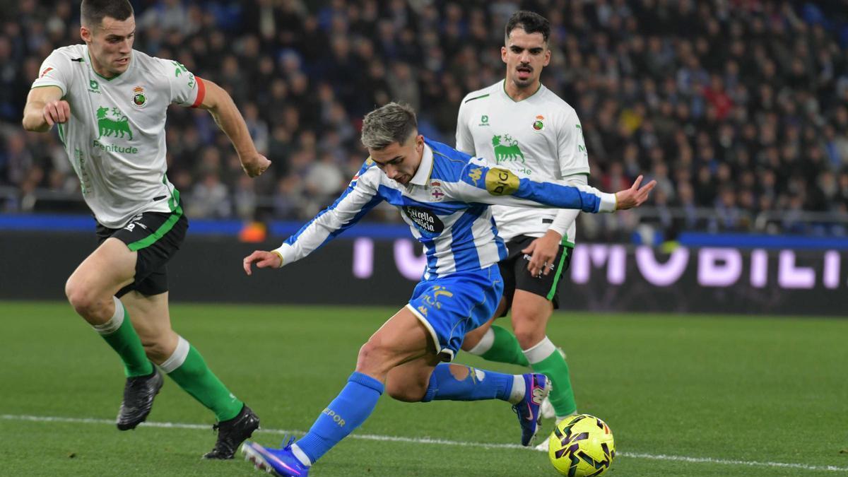 Yeremay encara a dos jugadores del Racing de Santander, la temporada pasada, en Riazor.