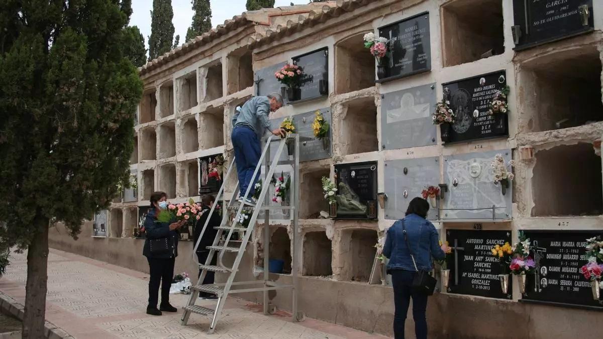 Vecinos preparan las lápidas de sus difuntos en el cementerio de San Clemente de Lorca.
