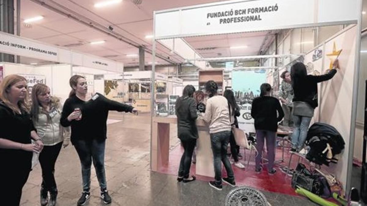 Tres chicas observan los preparativos , ayer, del Saló de l'Ensenyament.