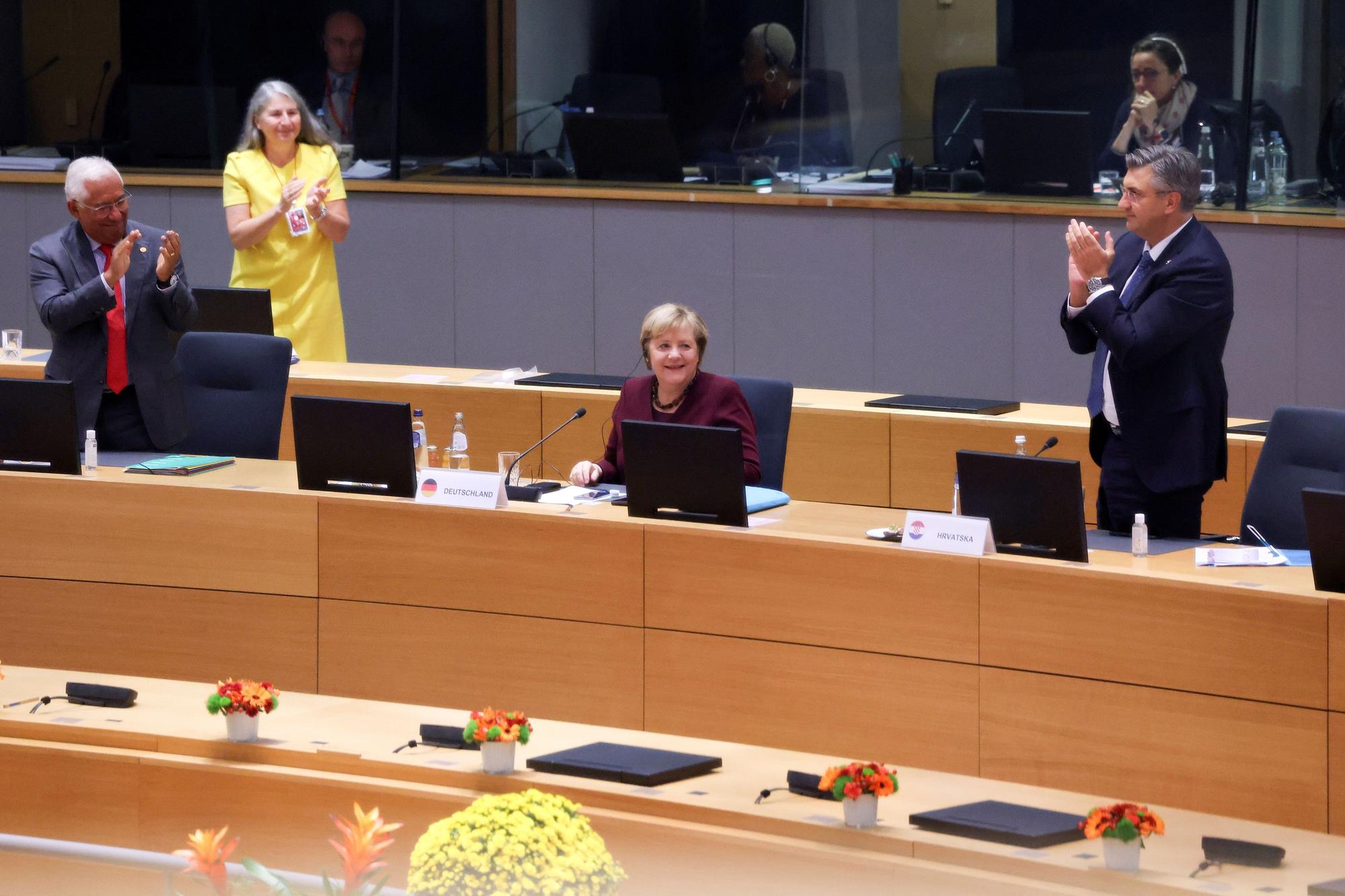Los líderes europeos se ponen en pie para ovacionar a la ex canciller alemana Angela Merkel.