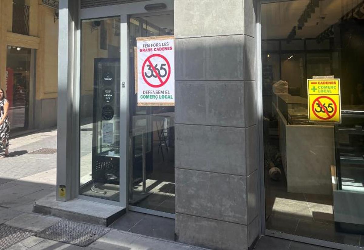 Aparador del 365 d'Olot vandalitzat amb cartells en contra de l'obertura