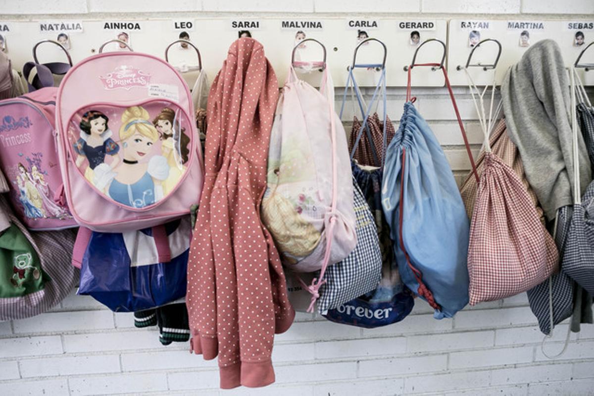 Las mochilas y la ropa de los niños en los colgadores con sus nombres.