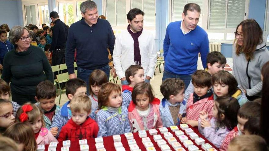 Ferreira, Martínez, Uzal, Sinde y alumnos de O Foxo, mirando las etiquetas navideñas. // Bernabé / Ana Agra