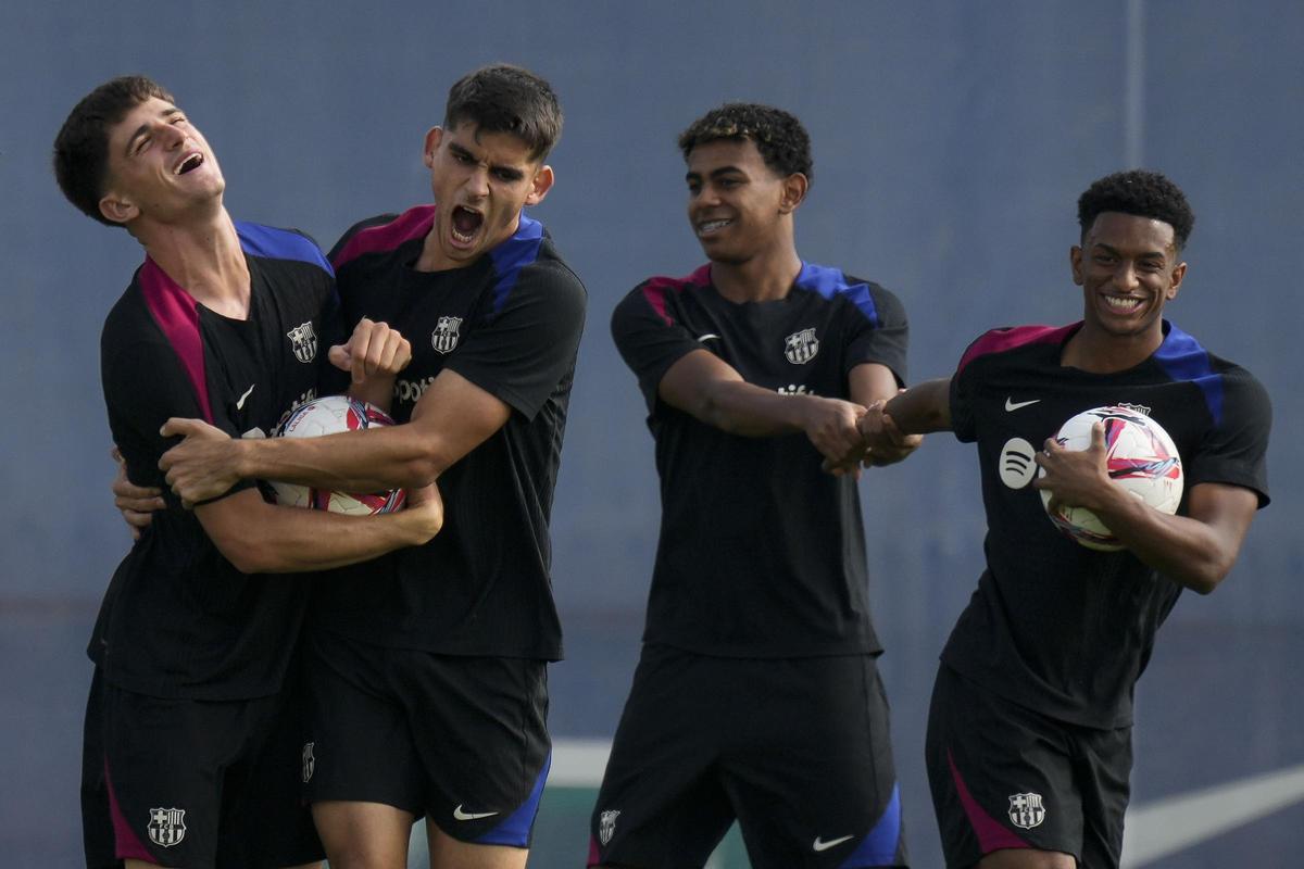 os jugadores Pau Victor (i), Gerard Martin (2i), Lamine Yamal (2d) y Alex Balde (d) durante el entrenamiento del primer equipo del FC Barcelona, este martes.