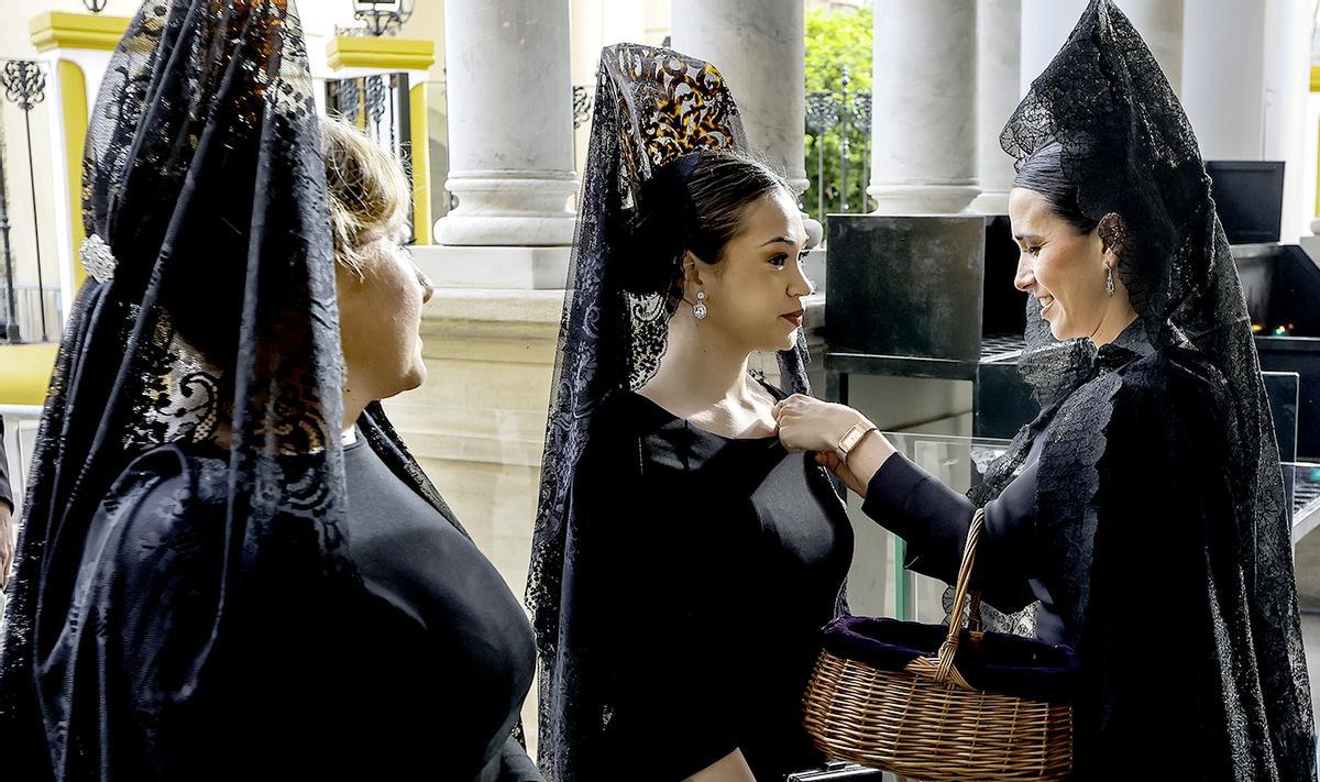 Mujeres de mantilla esperan para poder visitar la basílica de La Macarena hoy Jueves Santo antes de que esta hermandad salga en procesión esta noche en la Madrugá sevillana.