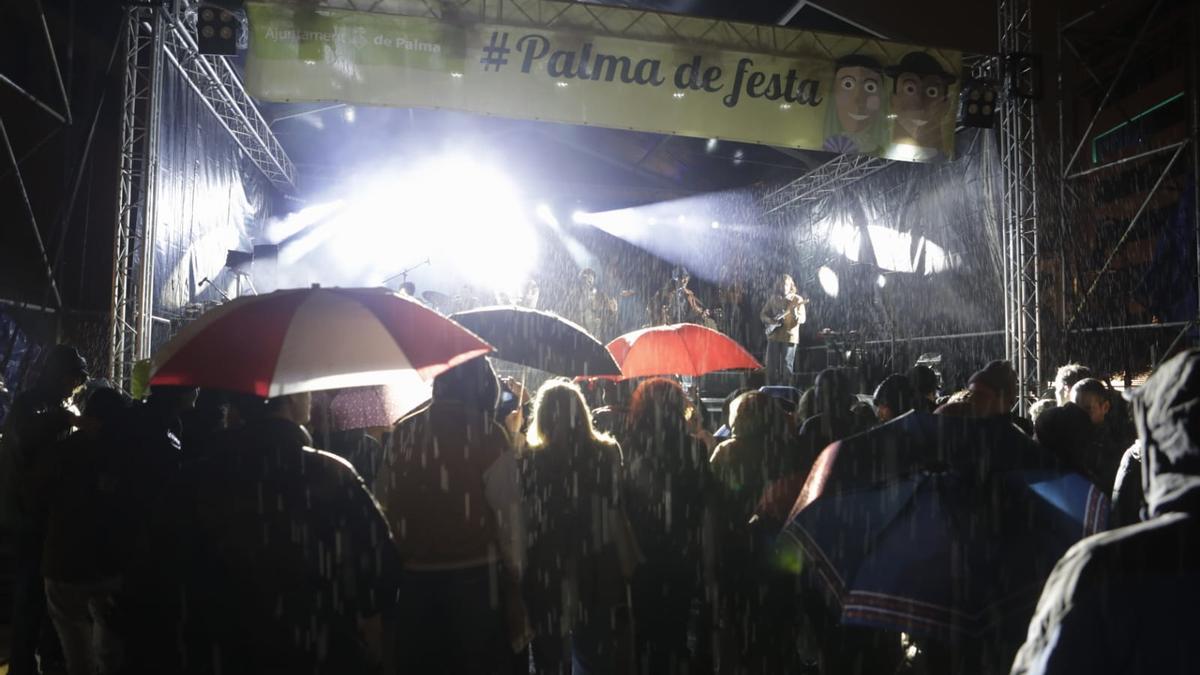 El público se protege de la lluvia con paraguas en el inicio de la Revetla de Sant Sebastià de Palma