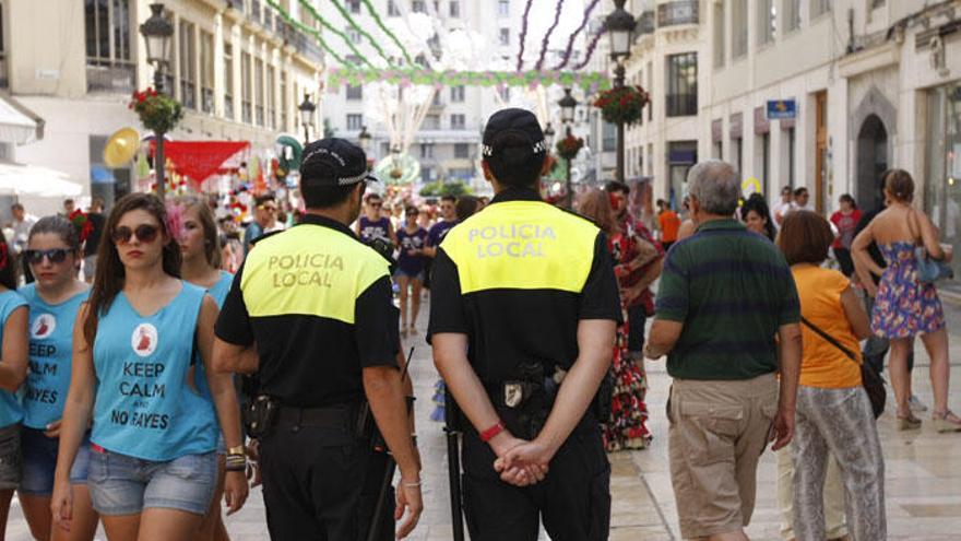 Una pareja de la Policía Local patrullando en la calle Larios durante la Feria.