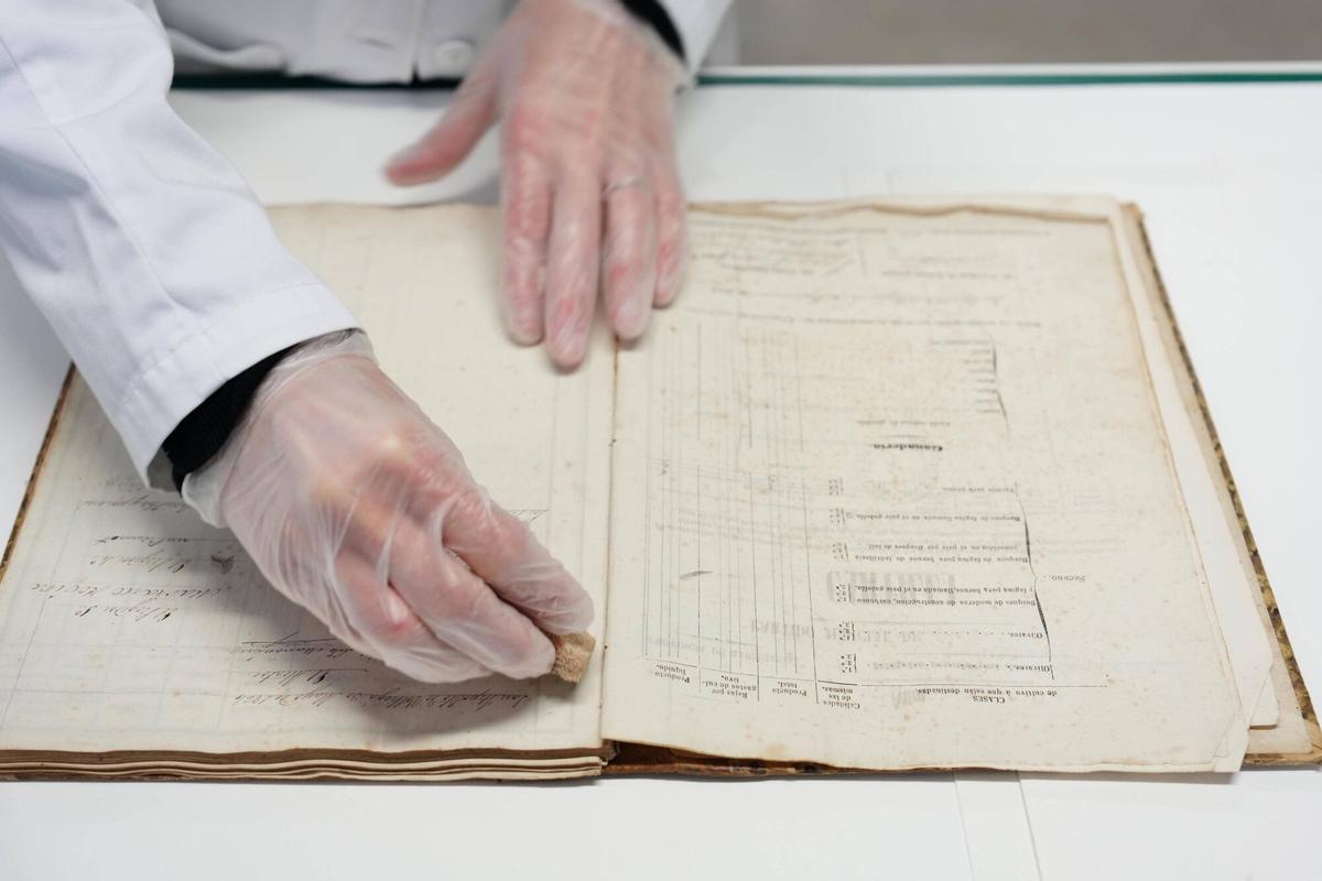 Un delicado trabajo de limpieza de documentos dañados por el tiempo.
