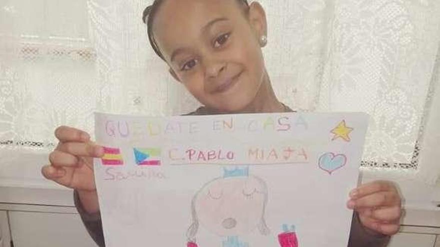 Carmen Samira Ava Piñeiro, mostrando un dibujo con el lema &quot;Quédate encasa&quot;.