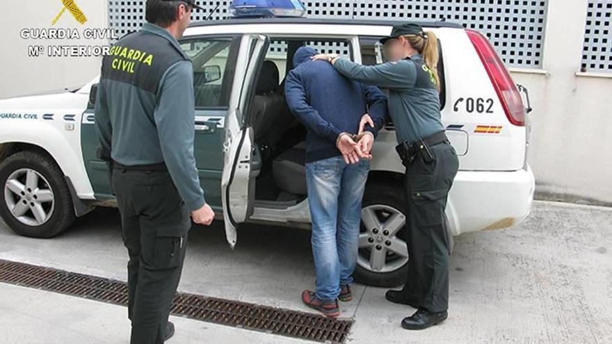 La Guardia Civil introduce en el coche a uno de los detenidos.