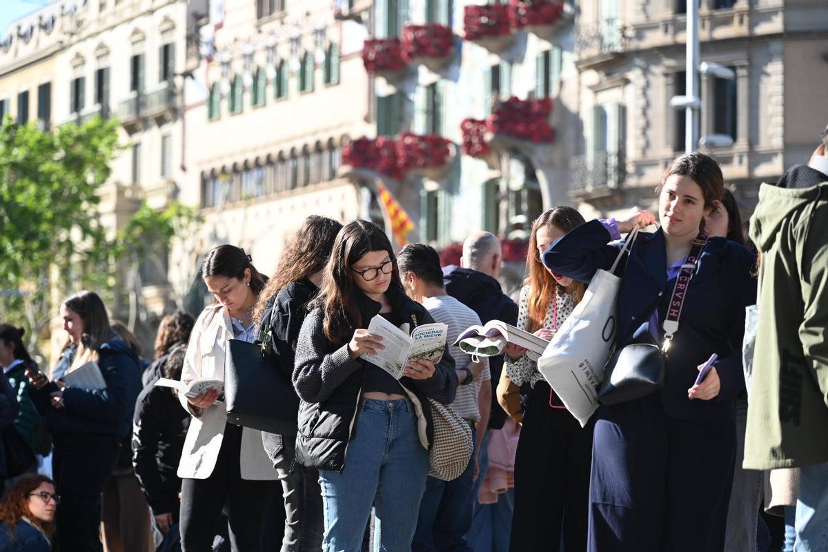 Jóvenes aguardan en fila en el paseo de Gràcia de Barcelona para conseguir la firma de Javier Castillo.