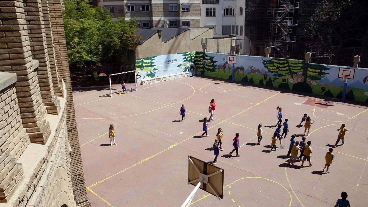 Un grupo de niños juegan en el patio de su colegio.