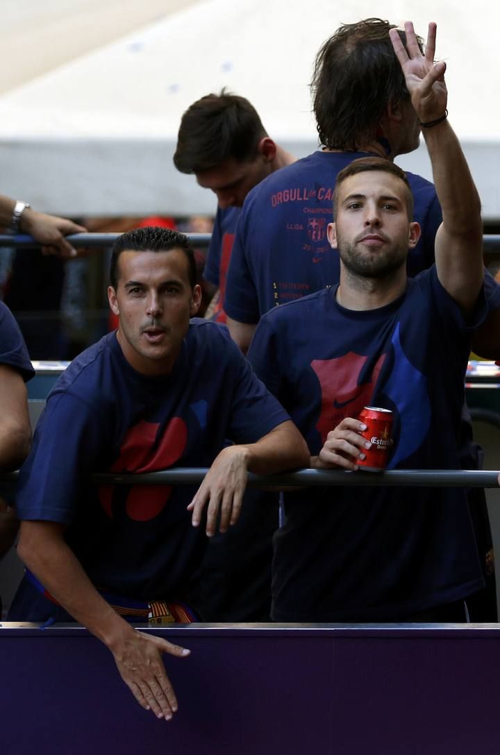 Barcelona's Pedro and Alba celebrate from an open-top bus during celebration parade in Barcelona