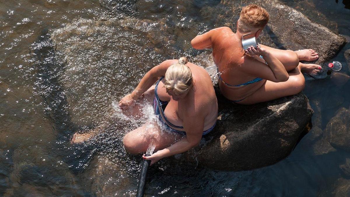 Dos mujeres se refrescan en las aguas del río Miño