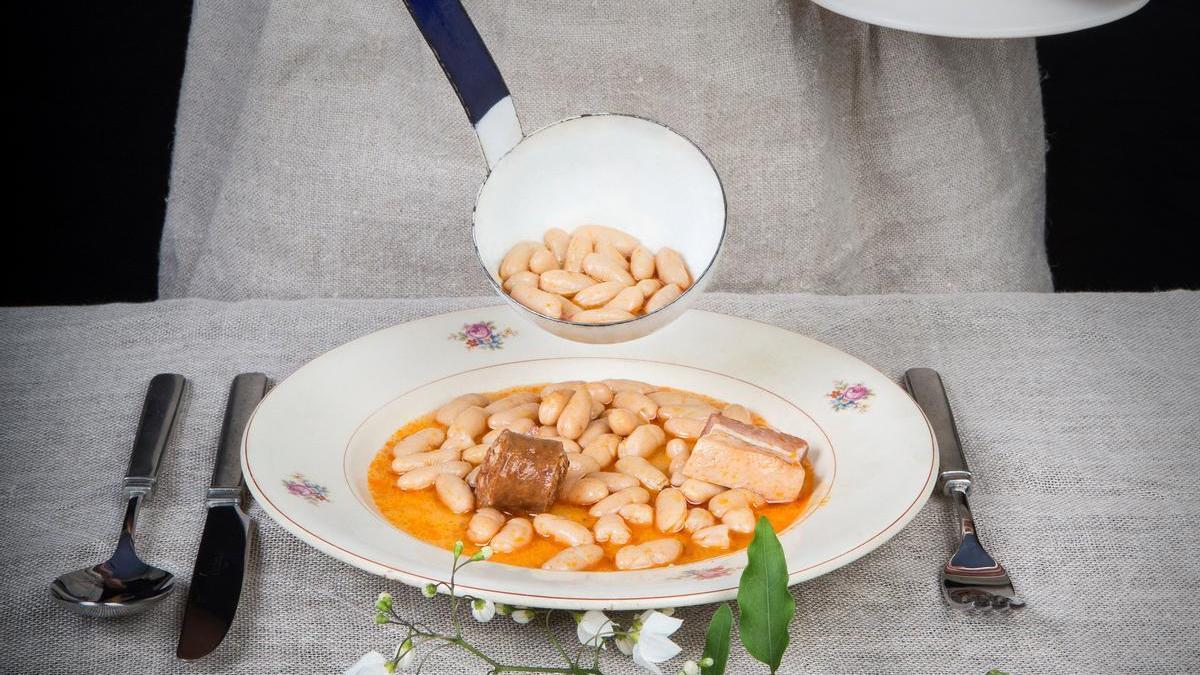 Una mujer sirviendo fabada asturiana