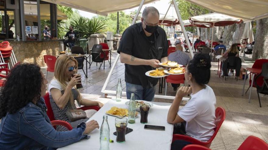 Un camarero atiende a tres clientas en un bar de Xàtiva. | PERALES IBORRA