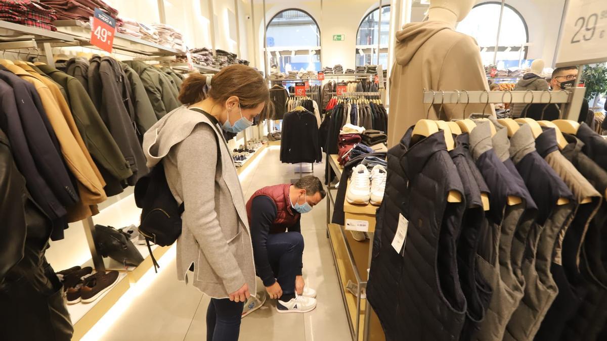 Un cliente se prueba unas zapatillas en un comercio de Córdoba.