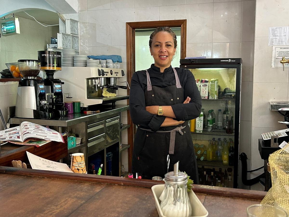 Kely posa en la barra de su restaurante, su centro de mando.