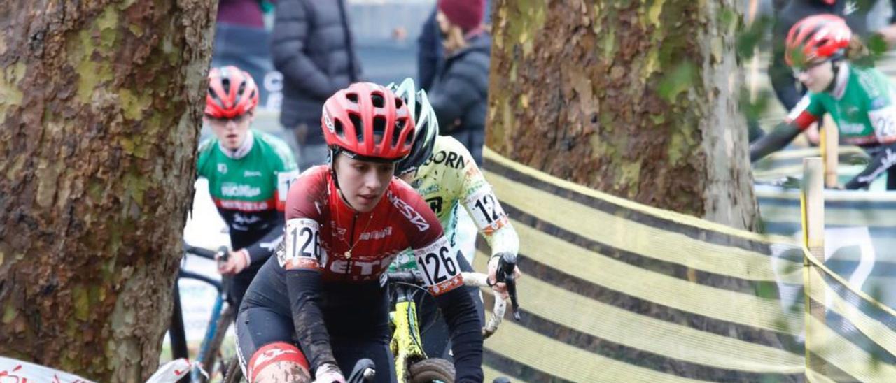 A la izquierda, Natalia Alonso durante la carrera. A la derecha, un corredor supera uno de los obstáculos. | Á. G.