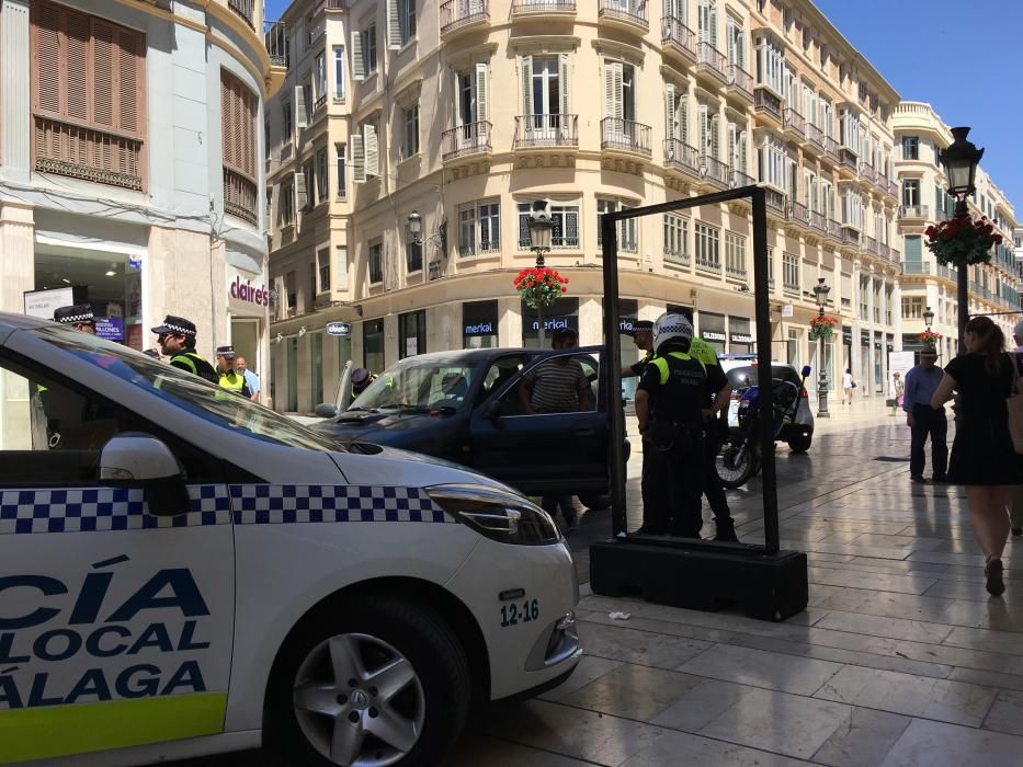 Detención de un hombre con su coche en la calle Larios.
