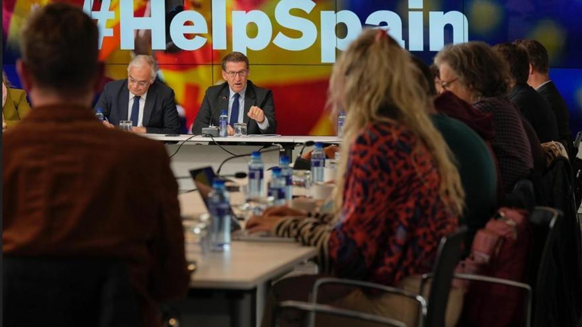 Feijóo, con los correponsales extranjeros y el lema detrás de él &quot;Ayuda a España&quot;.