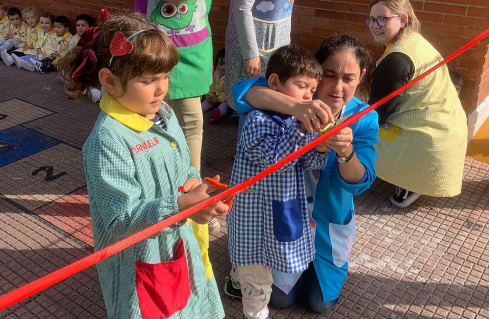 Por la izquierda, Manuela García y Leo Martín cortan la cinta roja para estrenar el patio junto a las profesoras Laura Vázquez y Laura Huergo. | M. L.