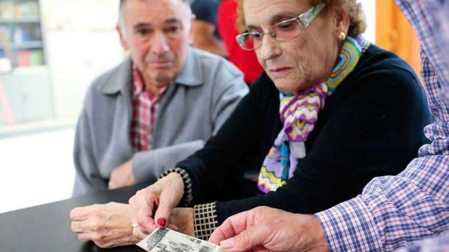 Charo Alonso, junto a su marido, Herminio Álvarez, revisando fotografías antiguas de Olivares.