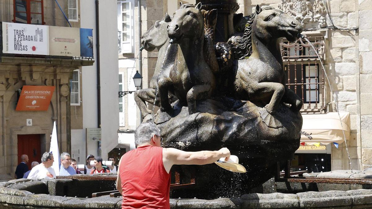 Turista refrescándose en la praza de Praterías en Santiago.