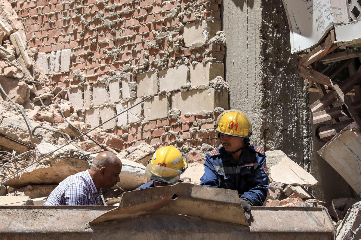 Los socorristas de defensa civil buscan entre los escombros en la escena de un edificio derrumbado de 13 pisos en el distrito de Sidi Bishr de la ciudad de Alejandría, en el norte de Egipto.