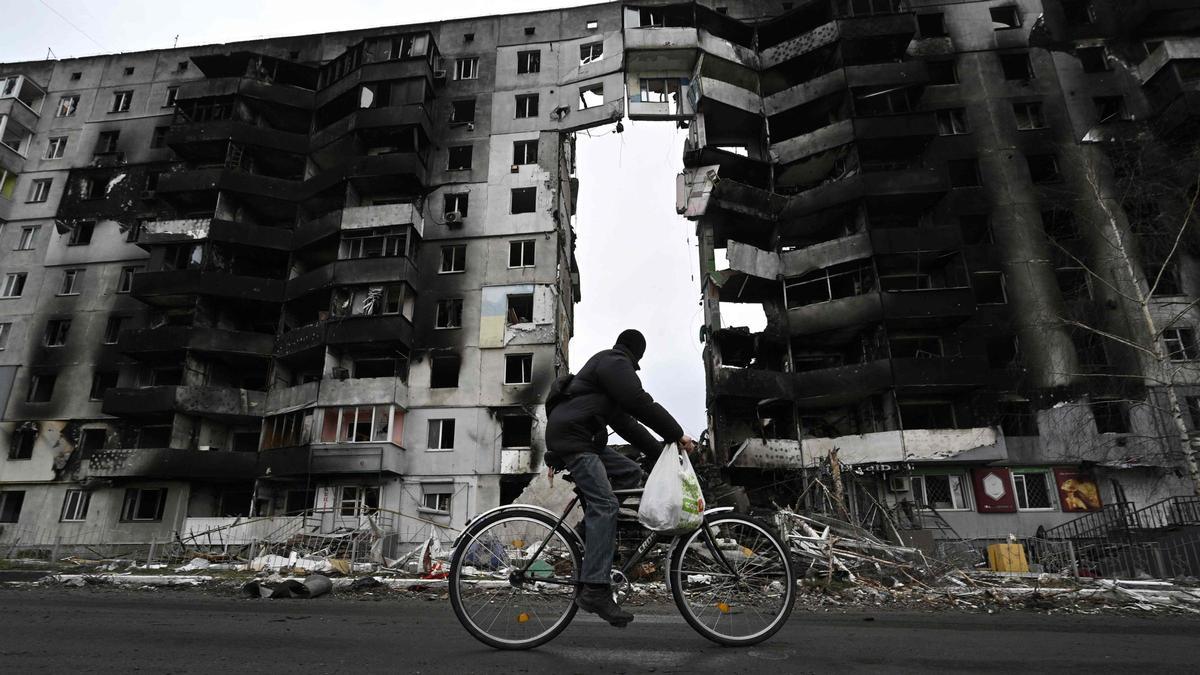 Un ciclista pasa junto a un edificio destruido en la ciudad de Borodianka, al noroeste de Kiev, el 6 de abril de 2022