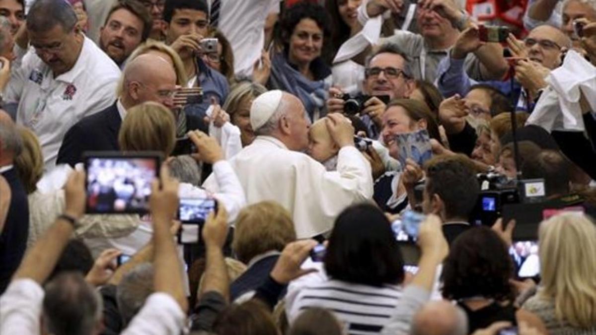 El Papa besa a un niño, ayer en el Vaticano, durante una audiencia con la red italiana de Bancos de Alimentos.