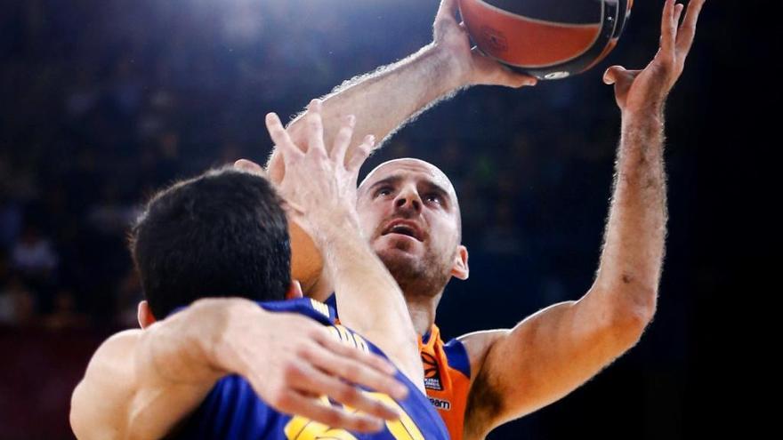 El base del Valencia, Colom, intenta lanzar defendido por Bolnaro, del Barça.