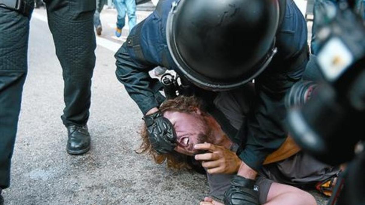 Unos mossos reducen a un indignado el pasado 27 de mayo en la plaza de Catalunya.