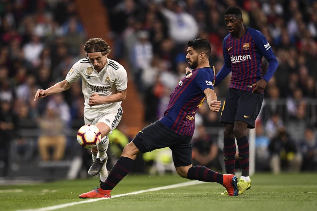 Luka Modric y Luis Suárez luchan por el balón durante el partido entre el Real Madrid y el FC Barcelona en el Estadio Santiago Bernabéu de la jornada 26 de La Liga.