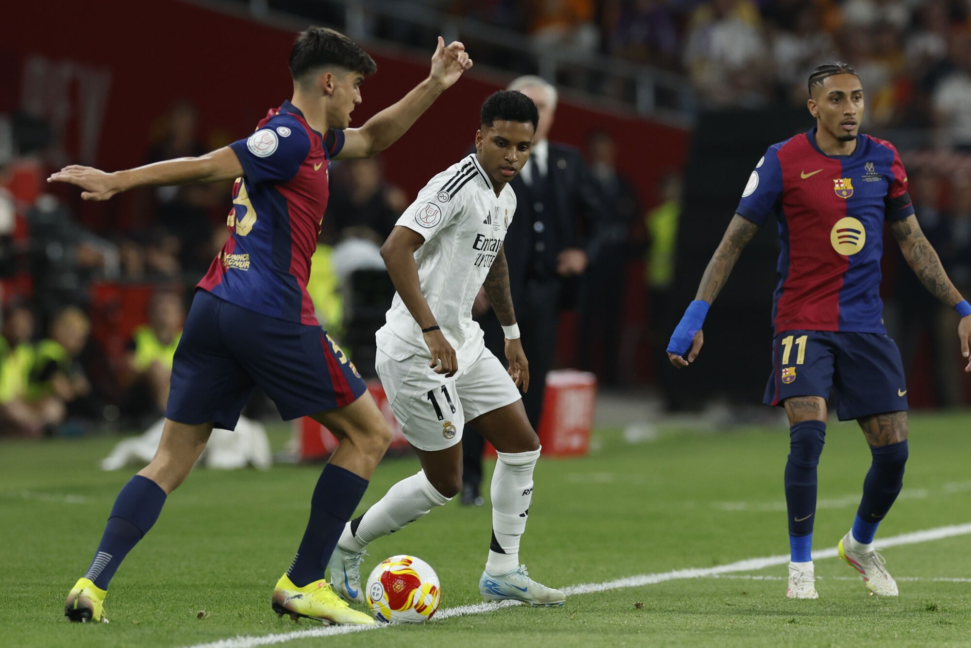 SEVILLA, 26/04/2025.- El defensa del FC Barcelona, Gerard Martín (i), disputa el balón ante el delantero brasileño del Real Madrid, Rodrygo, durante el encuentro correspondiente a la final de la Copa del Rey que disputan hoy sábado Real Madrid y FC Barcelona en el estadio de La Cartuja, en Sevilla. EFE / Julio Muñoz.