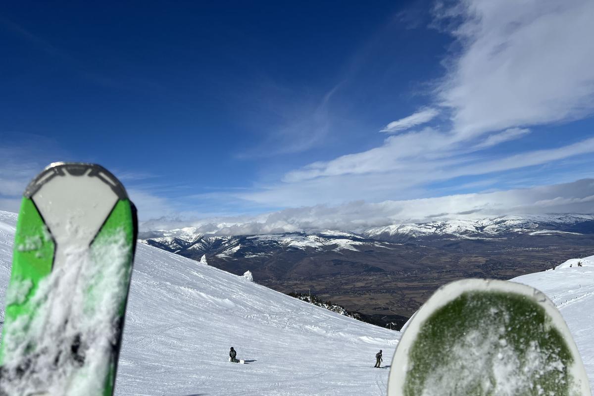 Dos esquiadors a les pistes de La Molina (Cerdanya) amb un paisatge emblanquinat i on es veuen uns esquís en primer pla