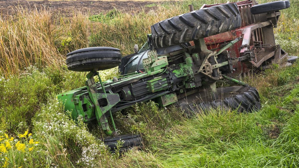 Un tractor volcado en imagen de archivo.