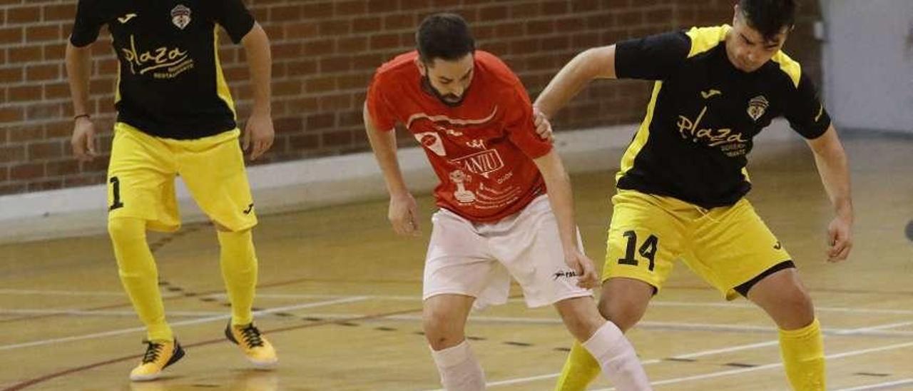 Un jugador del Cerilleru intenta mantener el balón ante el acoso de un rival.