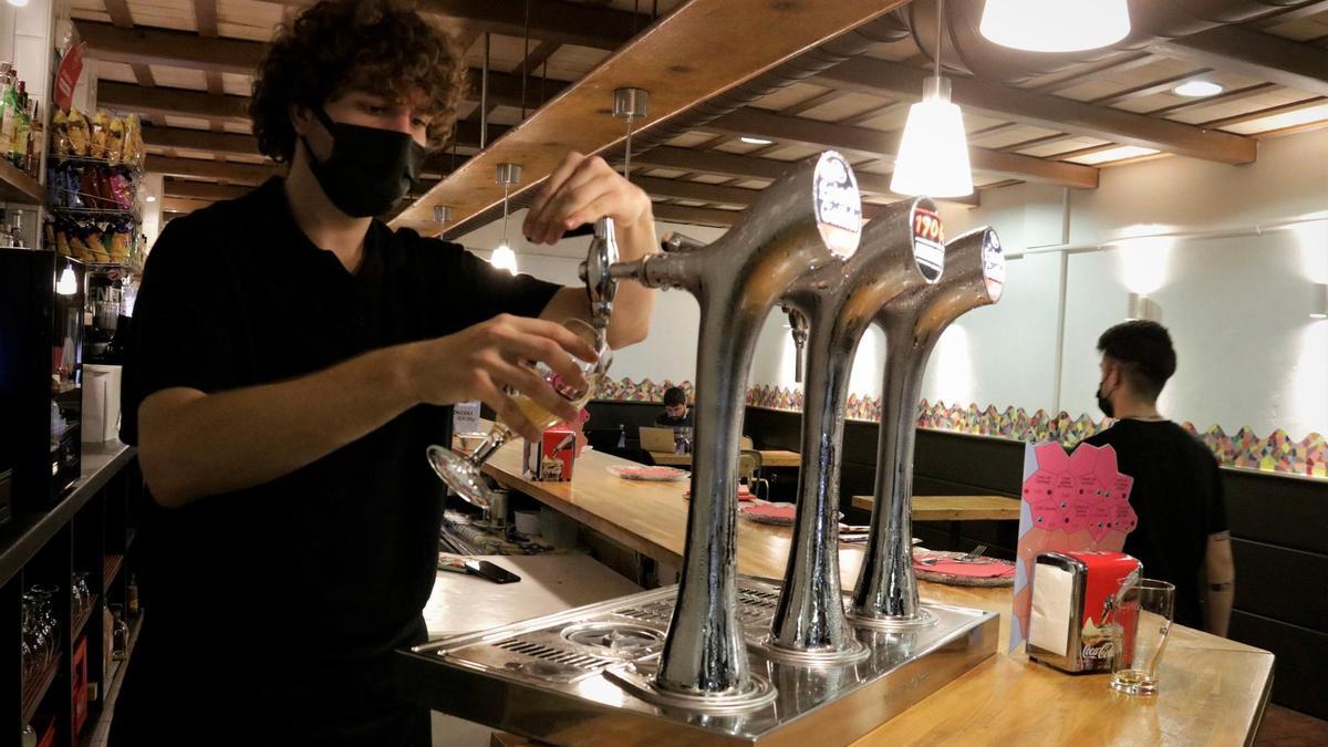 Un camarero sirve una cerveza en un bar de Santa Coloma de Gramenet.