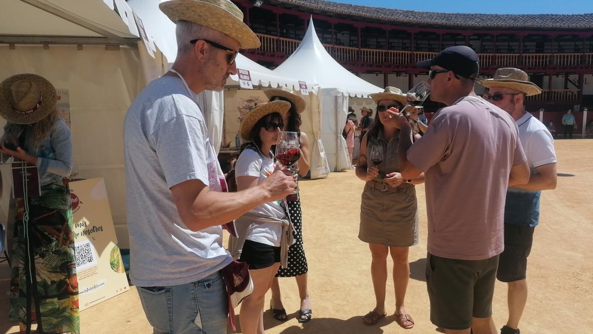 Visitantes de la Feria prueban un vino en la plaza de toros