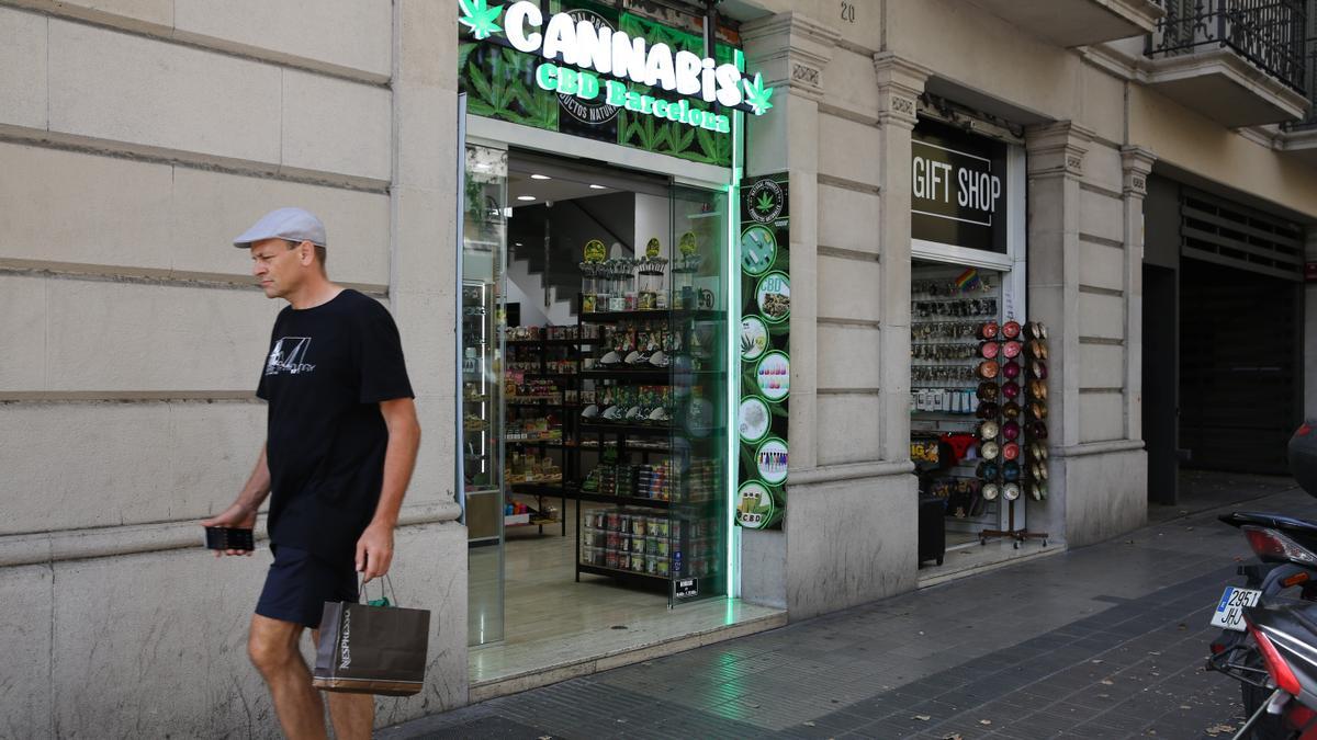 Antiguo colmado reconvertido en tienda cannábica más otra de regalos, en Urquinaona con Via Laietana.