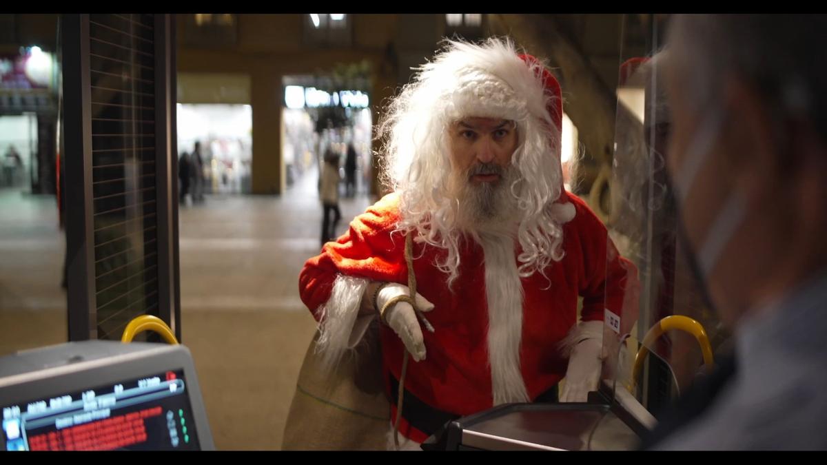 Santa Trepador intenta subir a un autobús de la EMT.