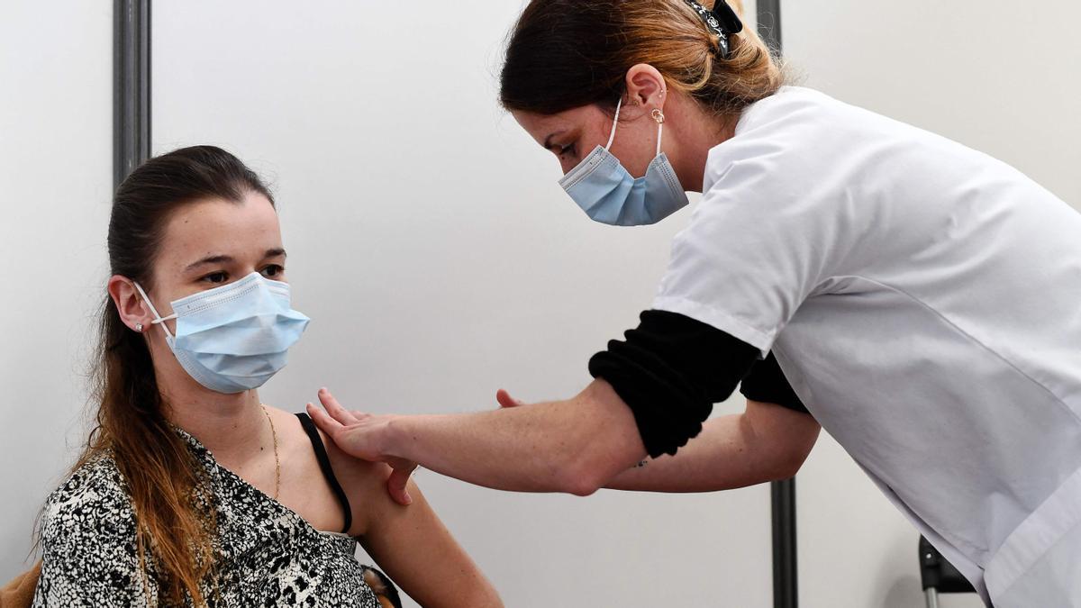 A woman receives a dose of the Pfizer-BioNtech Covid-19 vaccine at a vaccination military centre on May 11, 2021 in Brest, western France, amid a campaign of vaccination against the coronavirus. (Photo by Fred TANNEAU / AFP)