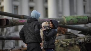 Una pareja junto a una instalación de vehículos militares rusos destruidos, en el centro de Kiev.