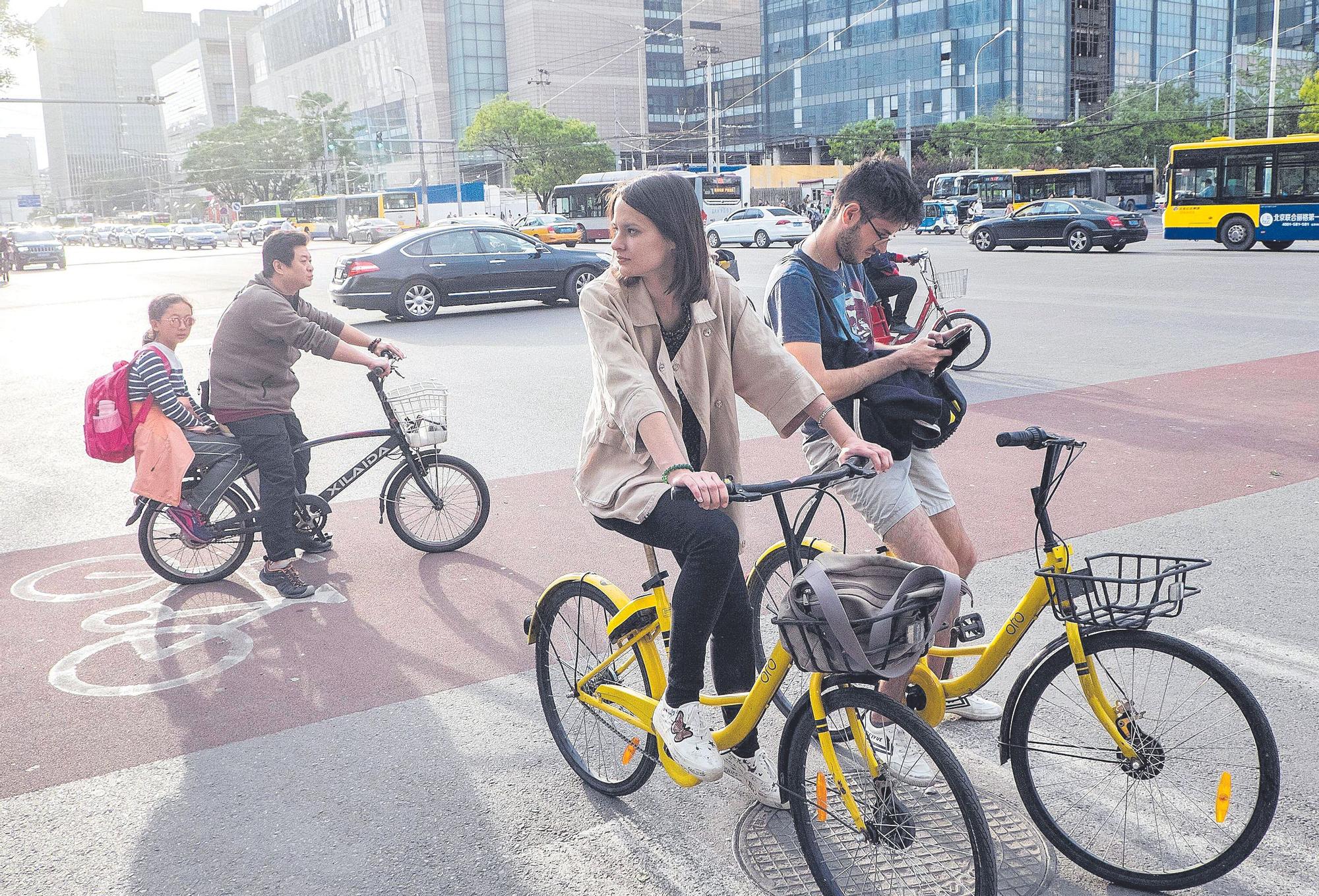 Turistas occidentales  en biciCleta por la capital  de China, Pekín.