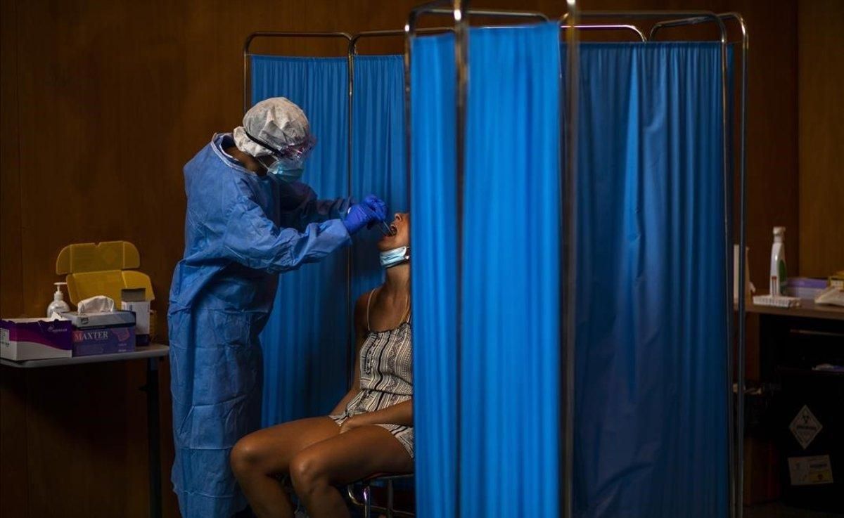 Un voluntario de la ONG Open Arms realiza un test PCR a un paciente en Vilafranca del Penedès.