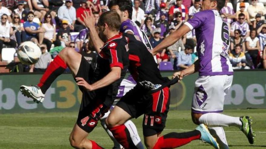 Rueda, del Valladolid, sujeta por la camiseta a Riki, junto a Bergantiños, ayer, en Zorrilla. // R. García