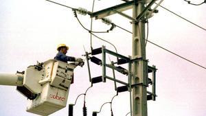 Un equip tècnic repara un pal d’electricitat.