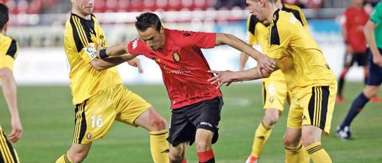 Óscar Díaz conduce el balón rodeado de rivales durante el partido de ayer ante Osasuna en el Iberostar Estadio.