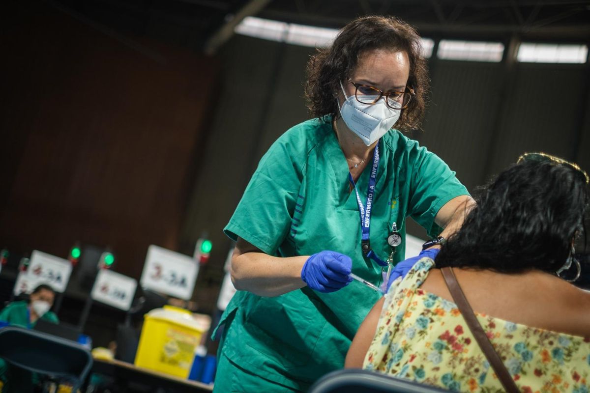 Una sanitaria administrando una vacuna.